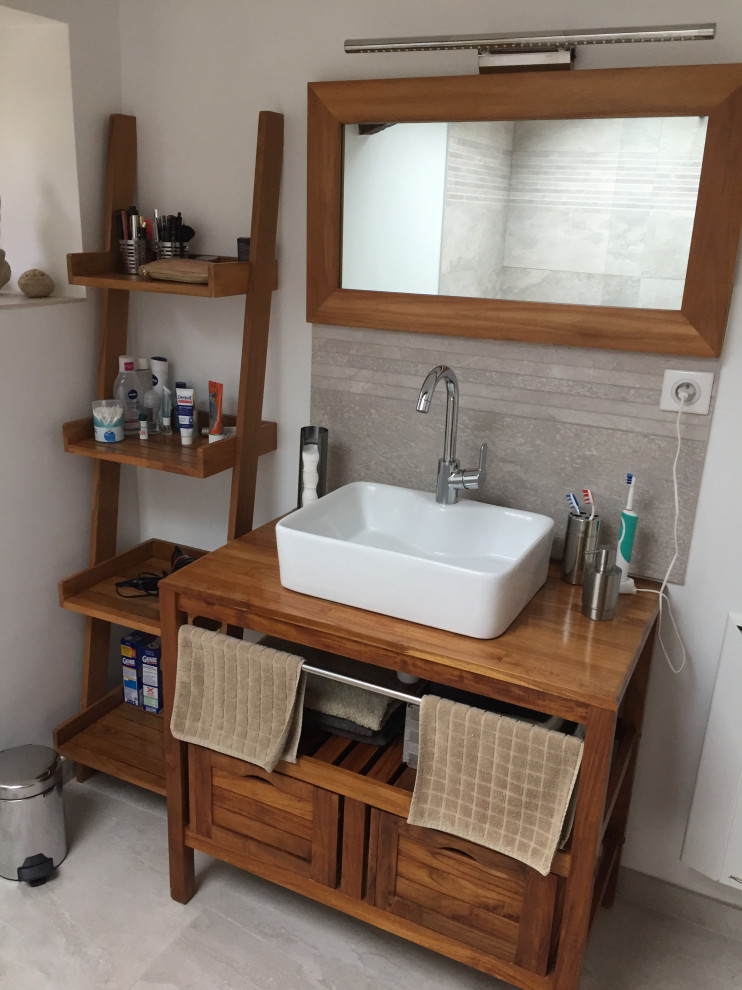 Inredning av ett modernt mellanstort brun brunt badrum med dusch, med skåp i mörkt trä, en kantlös dusch, grå kakel, vita väggar, vinylgolv, ett fristående handfat, träbänkskiva och grått golv