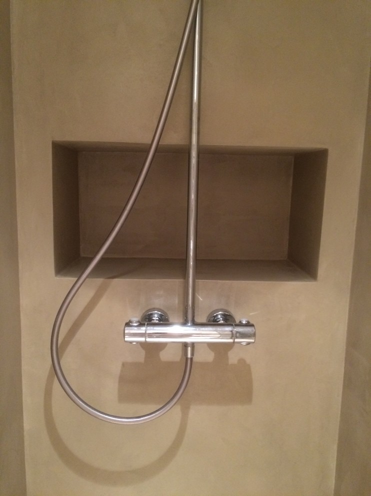 Aménagement d'une salle d'eau contemporaine avec une douche à l'italienne, un mur beige et sol en béton ciré.