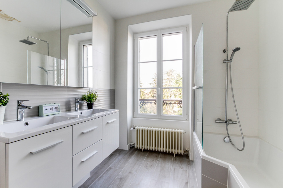 Пример оригинального дизайна: большая главная ванная комната в скандинавском стиле с фасадами с декоративным кантом, белыми фасадами, угловой ванной, серой плиткой, керамической плиткой, консольной раковиной и белой столешницей
