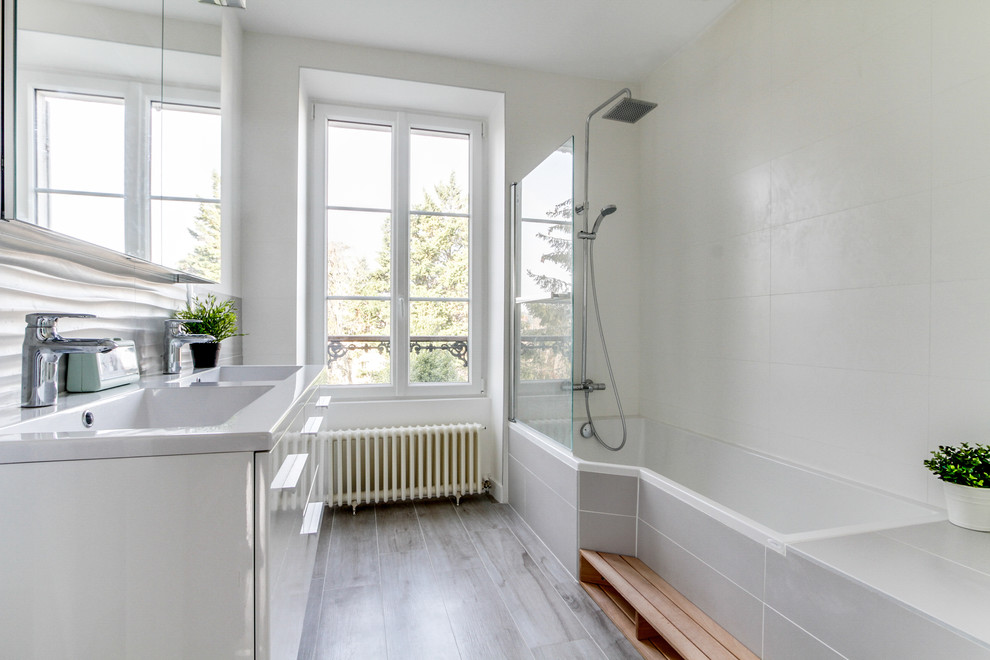 Foto på ett stort nordiskt vit en-suite badrum, med luckor med profilerade fronter, vita skåp, ett hörnbadkar, grå kakel och keramikplattor
