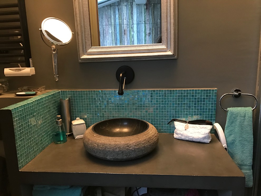 Idee per una stanza da bagno eclettica con doccia a filo pavimento, piastrelle blu, piastrelle di vetro, lavabo da incasso e top in cemento