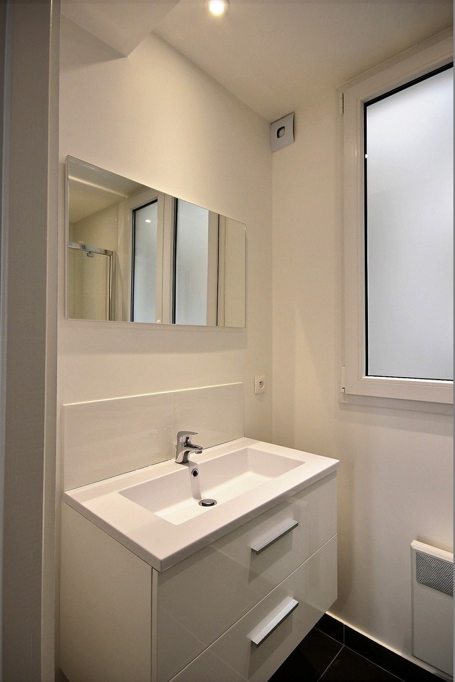 Cette image montre une salle de bain victorienne avec des portes de placard blanches, un carrelage blanc, une vasque et une cabine de douche à porte battante.