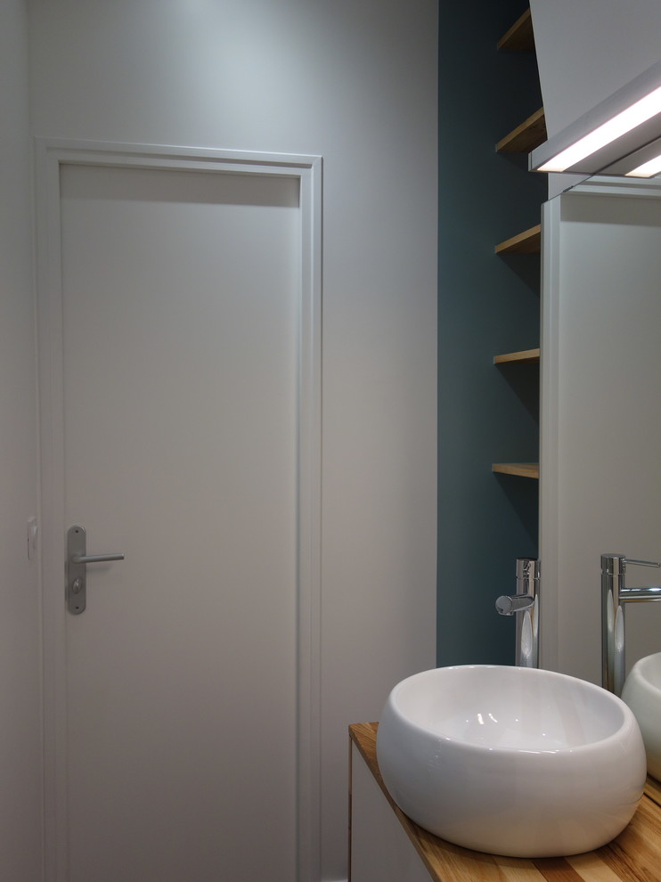 Aménagement d'une petite salle de bain principale contemporaine avec une douche ouverte, WC à poser, un carrelage blanc, des carreaux de céramique, un mur bleu, un sol en linoléum, une vasque et un plan de toilette en bois.