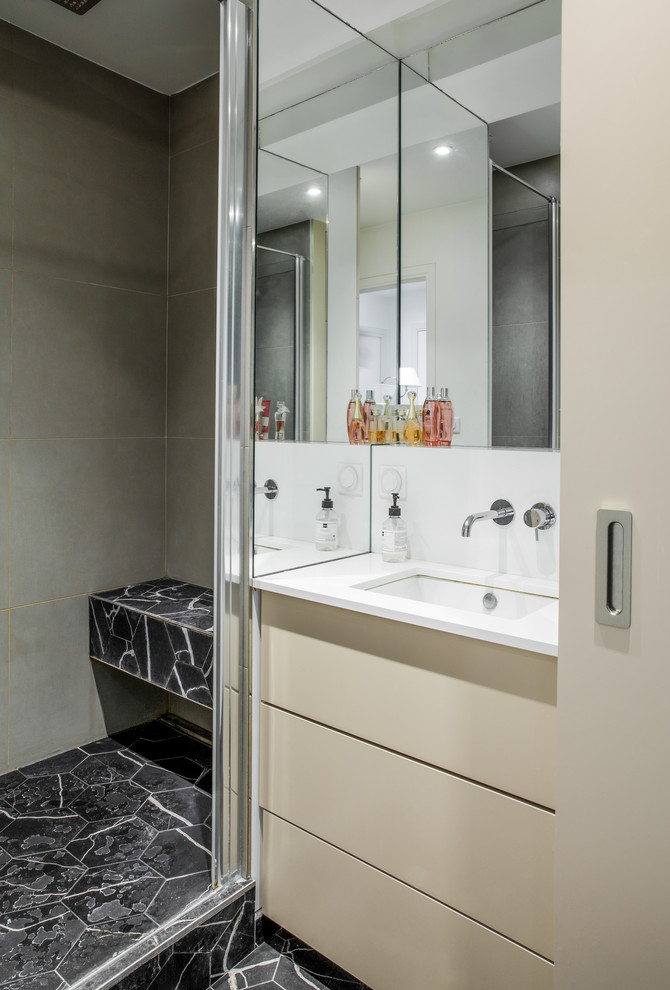 Exemple d'une salle de bain principale scandinave de taille moyenne avec des portes de placard beiges, un carrelage gris, un mur gris, un sol en carrelage de céramique, un lavabo encastré, un sol noir, une cabine de douche à porte coulissante et un plan de toilette blanc.