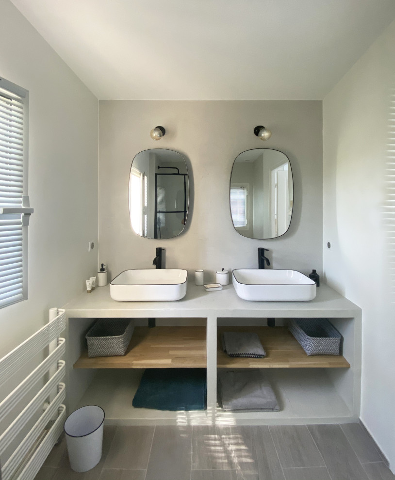 This is an example of a medium sized nautical bathroom in Nice with a freestanding bath, a walk-in shower, grey walls, wood-effect flooring, a built-in sink, concrete worktops, grey worktops, a wall niche, double sinks and a floating vanity unit.