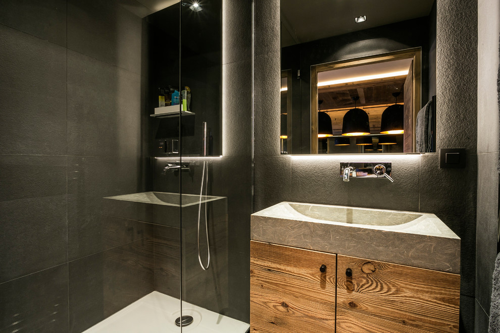 Immagine di una stanza da bagno con doccia contemporanea con ante in legno scuro, doccia ad angolo, ante lisce, piastrelle grigie, pareti grigie e lavabo rettangolare