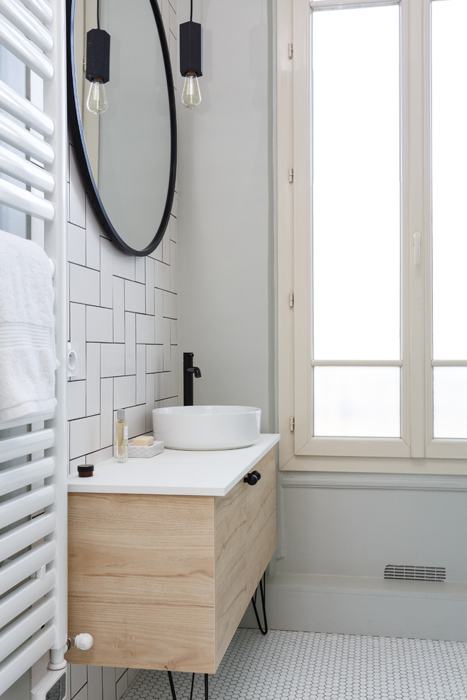 Стильный дизайн: главная ванная комната среднего размера в скандинавском стиле с плоскими фасадами, светлыми деревянными фасадами, накладной ванной, душем над ванной, раздельным унитазом, белой плиткой, керамогранитной плиткой, белыми стенами, полом из мозаичной плитки, настольной раковиной, столешницей из искусственного камня, белым полом, душем с распашными дверями и белой столешницей - последний тренд