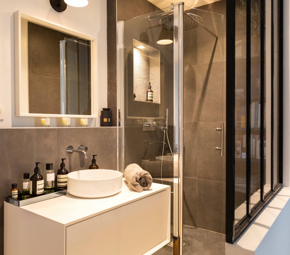 Inredning av ett modernt litet en-suite badrum, med öppna hyllor, vita skåp, en kantlös dusch, brun kakel, bruna väggar, ett konsol handfat, dusch med gångjärnsdörr och keramikplattor