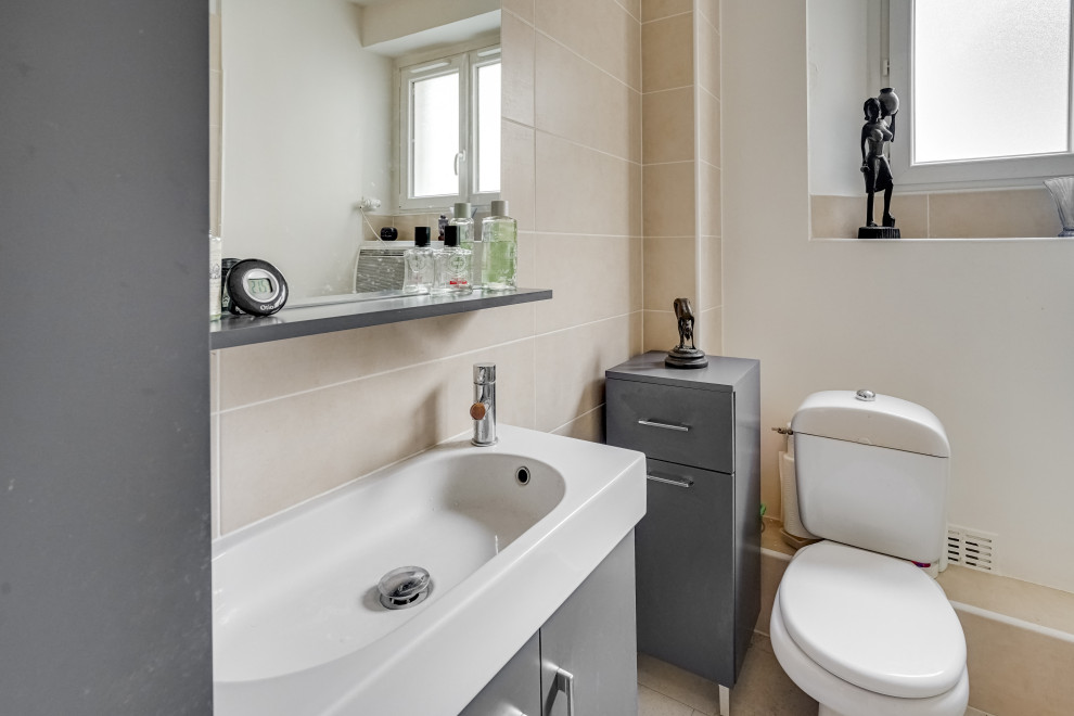 Idéer för ett litet modernt beige badrum med dusch, med grå skåp, en hörndusch, en toalettstol med hel cisternkåpa, beige kakel, cementkakel, beige väggar, cementgolv, ett avlångt handfat, kaklad bänkskiva, grått golv och dusch med skjutdörr