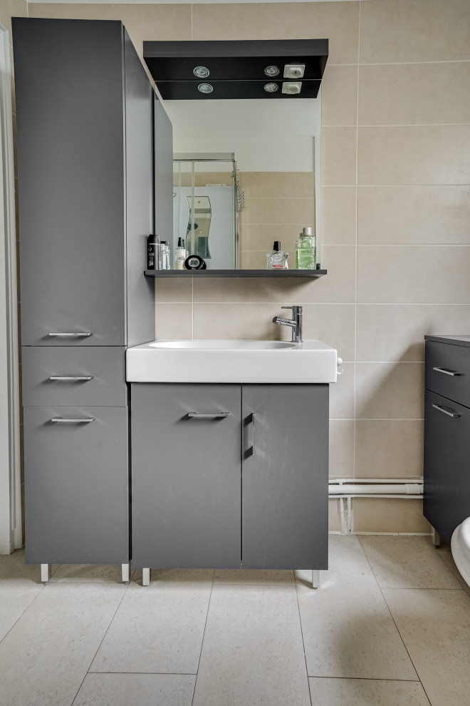 Exempel på ett litet modernt beige beige badrum med dusch, med grå skåp, en hörndusch, en toalettstol med hel cisternkåpa, beige kakel, cementkakel, beige väggar, cementgolv, ett avlångt handfat, kaklad bänkskiva, grått golv och dusch med skjutdörr
