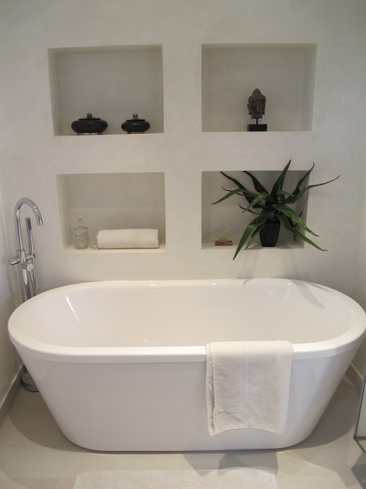 Cette photo montre une petite salle de bain principale tendance avec une baignoire indépendante et un mur blanc.