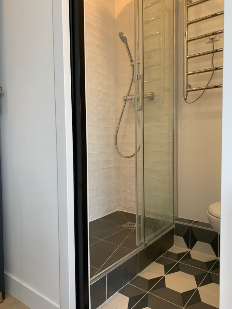 Design ideas for a small modern shower room bathroom in Paris with flat-panel cabinets, white cabinets, an alcove shower, a wall mounted toilet, white tiles, ceramic tiles, white walls, cement flooring, a built-in sink, tiled worktops, grey floors, a sliding door and white worktops.