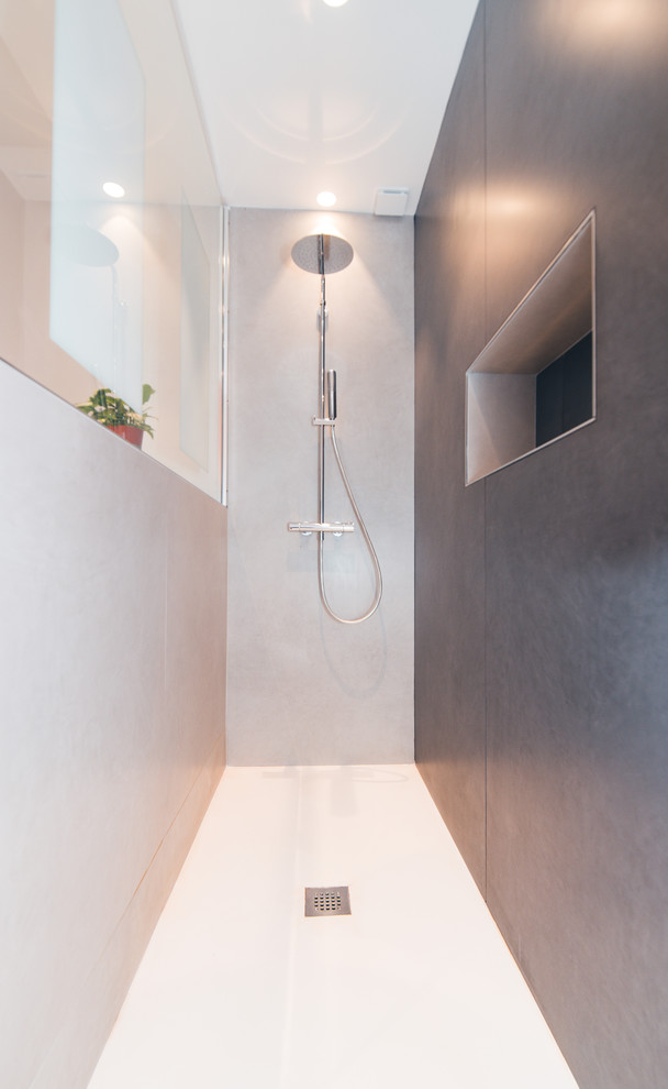 Modern inredning av ett mellanstort en-suite badrum, med en kantlös dusch, grå kakel, keramikplattor, orange väggar, klinkergolv i keramik, ett konsol handfat och grått golv