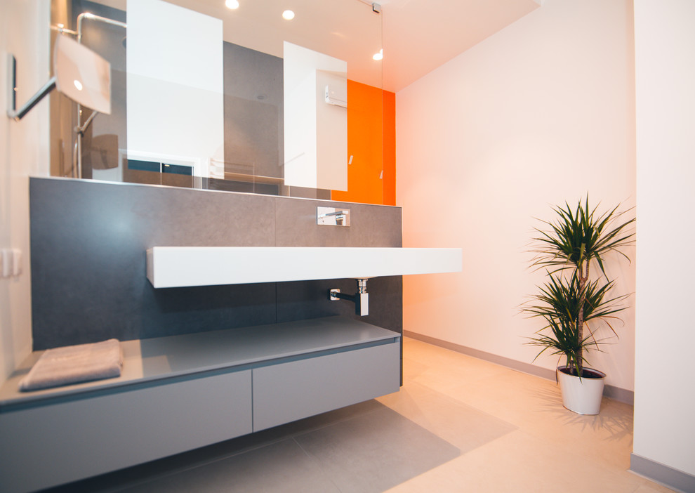 Стильный дизайн: главная ванная комната среднего размера в современном стиле с душем без бортиков, серой плиткой, цементной плиткой, оранжевыми стенами, полом из керамической плитки, консольной раковиной и серым полом - последний тренд