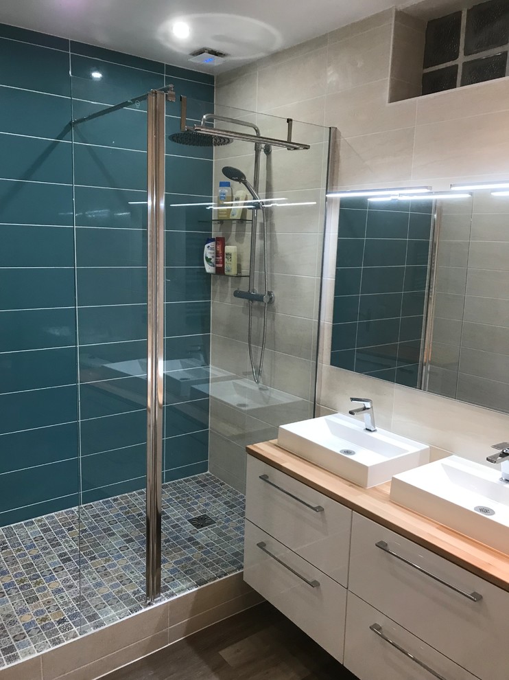 Exempel på ett mellanstort modernt en-suite badrum, med släta luckor, vita skåp, en öppen dusch, en toalettstol med hel cisternkåpa, flerfärgad kakel, keramikplattor, flerfärgade väggar, vinylgolv, ett fristående handfat, träbänkskiva och brunt golv