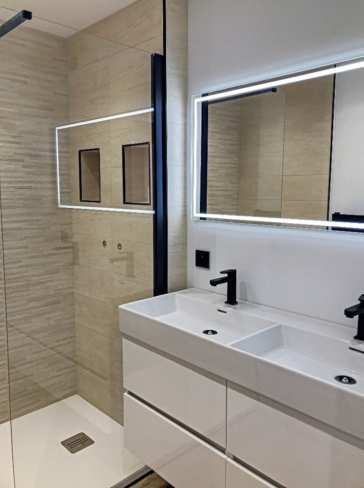Idéer för mellanstora funkis vitt en-suite badrum, med en kantlös dusch, en toalettstol med separat cisternkåpa, beige kakel, keramikplattor, vita väggar, vinylgolv, ett nedsänkt handfat och beiget golv