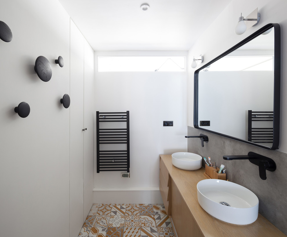 На фото: главная ванная комната среднего размера в скандинавском стиле с белыми фасадами, душем в нише, серой плиткой, терракотовой плиткой, белыми стенами, полом из керамической плитки, настольной раковиной, столешницей из дерева и душем с распашными дверями