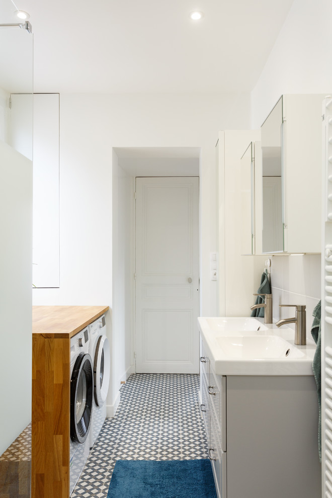 Inspiration for a mid-sized modern master gray tile and ceramic tile cement tile floor and multicolored floor walk-in shower remodel in London with raised-panel cabinets, white cabinets, a two-piece toilet, white walls, a console sink, solid surface countertops and white countertops