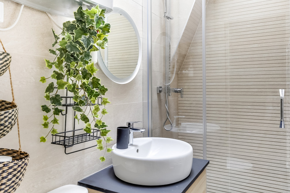 This is an example of a medium sized scandi shower room bathroom in Paris with flat-panel cabinets, light wood cabinets, beige tiles, ceramic tiles, beige walls, a vessel sink, black worktops, a sliding door and a one-piece toilet.