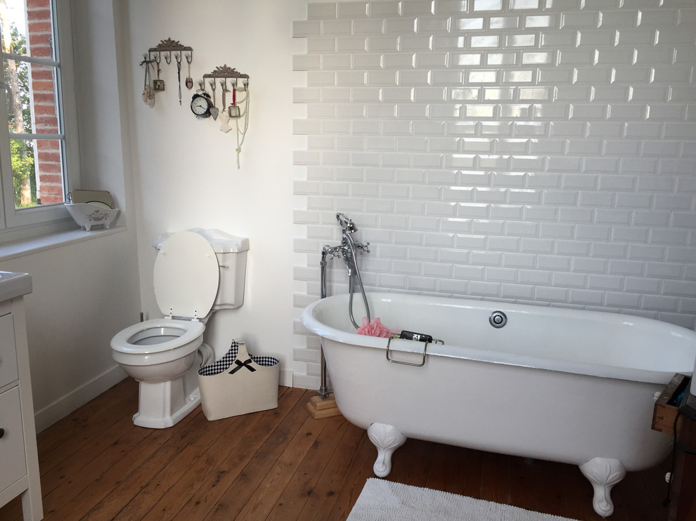 Идея дизайна: главная ванная комната среднего размера в стиле шебби-шик с ванной на ножках, плиткой кабанчик, унитазом-моноблоком, белой плиткой, белыми стенами, темным паркетным полом и коричневым полом