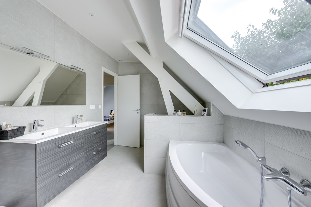 На фото: главная ванная комната в современном стиле с плоскими фасадами, серыми фасадами, накладной ванной, серой плиткой, серыми стенами, монолитной раковиной, серым полом и белой столешницей с