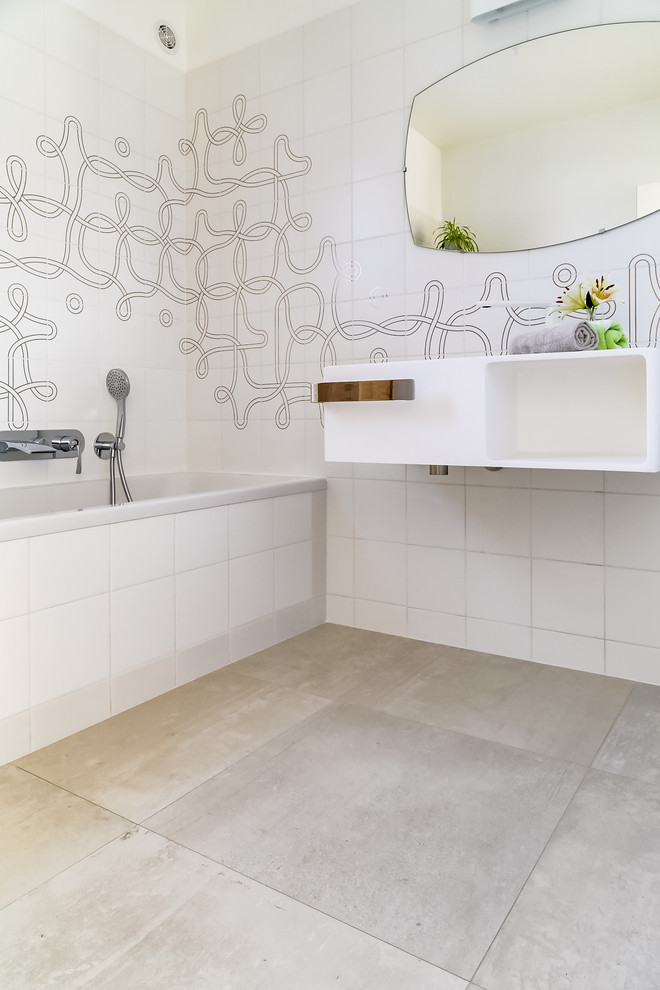 Idéer för att renovera ett mellanstort funkis en-suite badrum, med luckor med profilerade fronter, beige skåp, ett hörnbadkar, en kantlös dusch, vit kakel, cementkakel, vita väggar, ljust trägolv, ett avlångt handfat, bänkskiva i akrylsten, beiget golv och dusch med gångjärnsdörr
