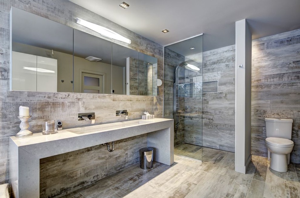 Diseño de cuarto de baño actual con lavabo de seno grande, ducha a ras de suelo, sanitario de dos piezas y aseo y ducha