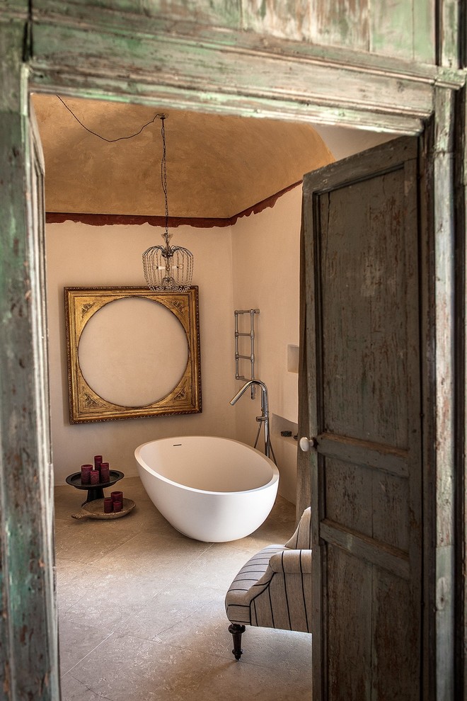 Источник вдохновения для домашнего уюта: маленькая главная ванная комната в средиземноморском стиле с отдельно стоящей ванной, бежевыми стенами, полом из известняка и серым полом для на участке и в саду
