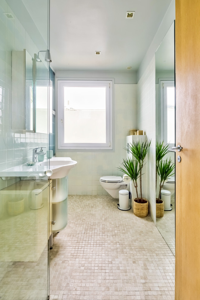 Idéer för mellanstora funkis blått badrum med dusch, med luckor med glaspanel, beige kakel, mosaikgolv, ett konsol handfat, beiget golv, dusch med gångjärnsdörr, skåp i ljust trä, en kantlös dusch, en vägghängd toalettstol, keramikplattor, gröna väggar och kaklad bänkskiva