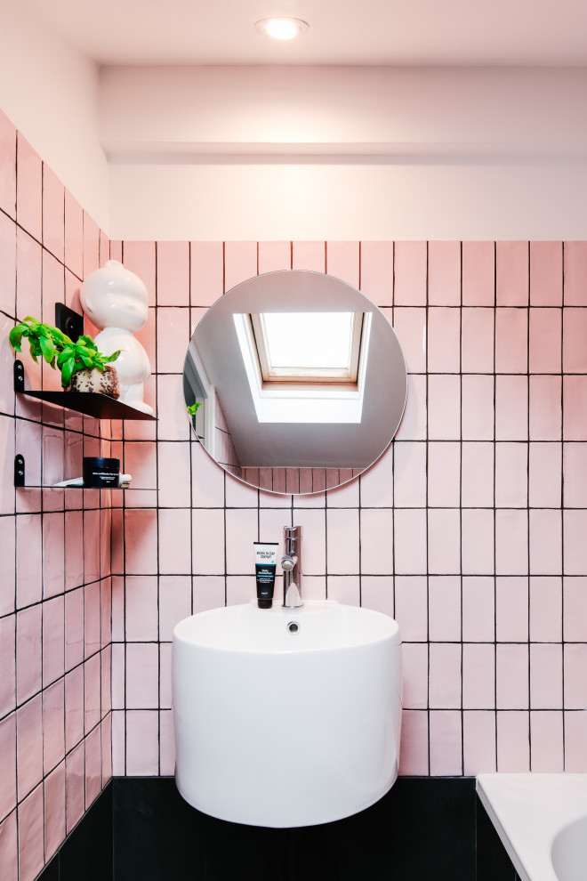 Bathroom - contemporary pink tile single-sink bathroom idea in Paris with white walls, a vessel sink and black countertops