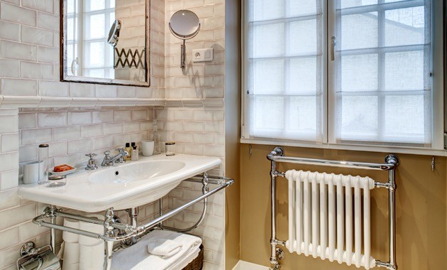 Small eclectic 3/4 white tile and terra-cotta tile ceramic tile and white floor bathroom photo in Paris with beaded inset cabinets, a wall-mount toilet, white walls, a console sink and solid surface countertops