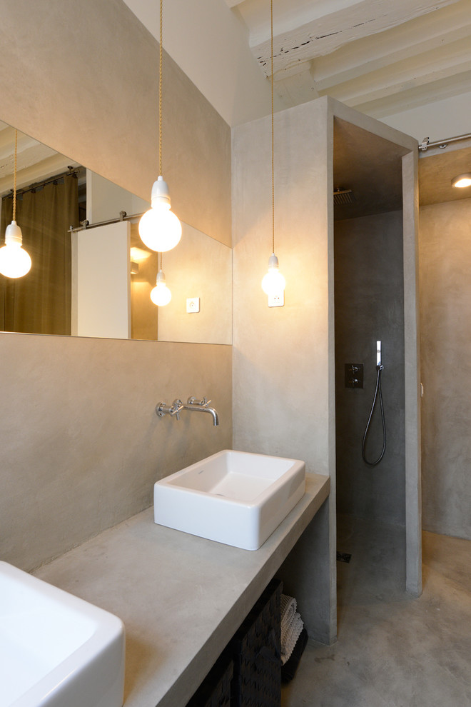 Imagen de cuarto de baño rectangular actual de tamaño medio con lavabo sobreencimera, encimera de cemento, paredes grises, suelo de cemento, aseo y ducha, ducha empotrada y microcemento