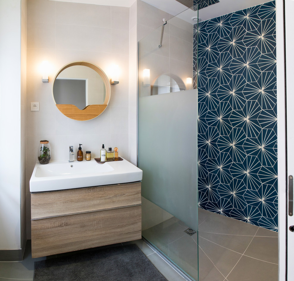 Foto på ett skandinaviskt badrum, med en kantlös dusch, blå kakel, cementkakel, vita väggar, betonggolv och ett väggmonterat handfat