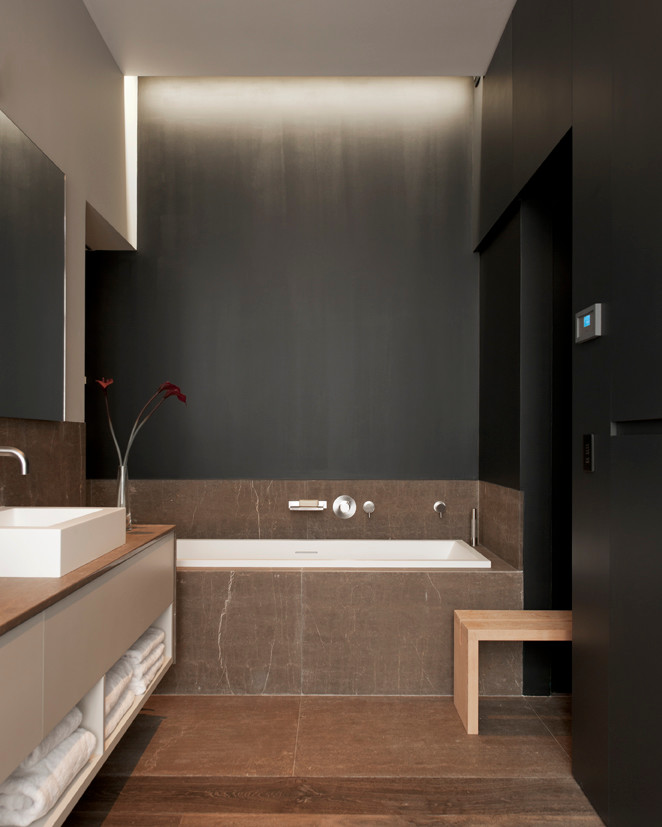 Inspiration för moderna en-suite badrum, med svarta väggar, mörkt trägolv, brunt golv, luckor med profilerade fronter, beige skåp, ett hörnbadkar, ett avlångt handfat och marmorbänkskiva