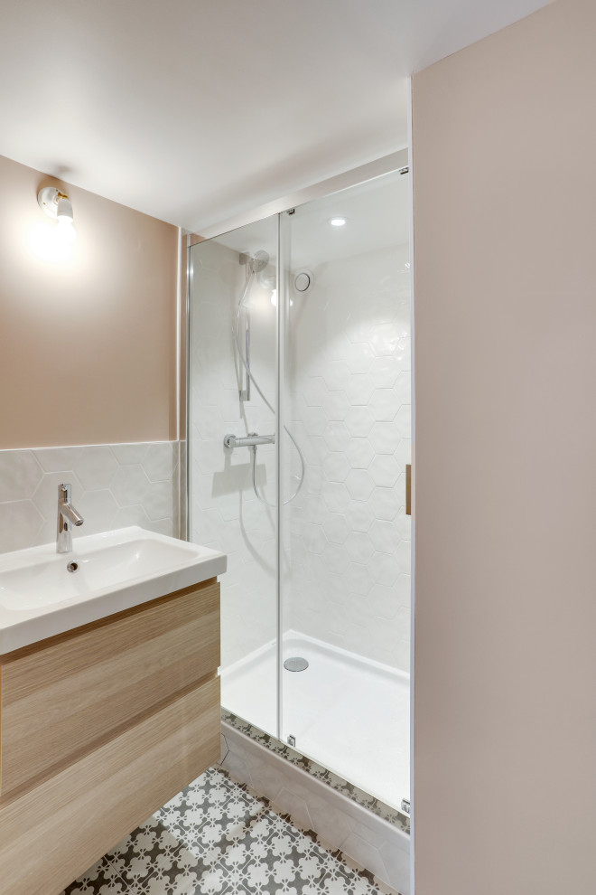 Foto på ett litet vit badrum för barn, med en dusch i en alkov, grå kakel, keramikplattor, rosa väggar, cementgolv, ett nedsänkt handfat, grått golv och dusch med skjutdörr