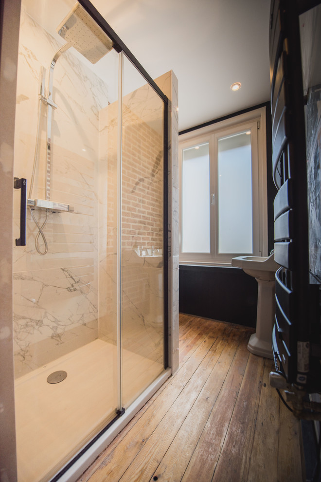 Cette image montre une petite salle de bain principale urbaine avec une douche à l'italienne, WC suspendus, un carrelage blanc, du carrelage en marbre, un mur noir, parquet clair, un lavabo de ferme, un sol beige et une cabine de douche à porte coulissante.