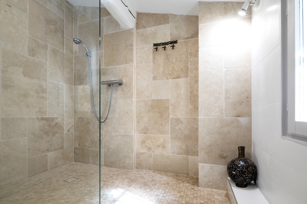 Bild på ett litet skandinaviskt badrum med dusch, med en kantlös dusch, en vägghängd toalettstol, travertinkakel, vita väggar, travertin golv, ett konsol handfat och beiget golv