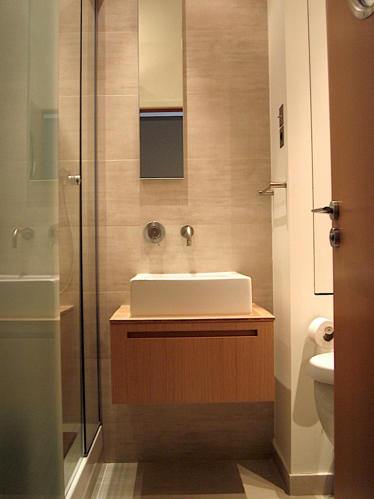 Exempel på ett litet modernt badrum med dusch, med släta luckor, skåp i ljust trä, en dubbeldusch, en vägghängd toalettstol, beige kakel, stenkakel, beige väggar, ett nedsänkt handfat, träbänkskiva, beiget golv och dusch med skjutdörr