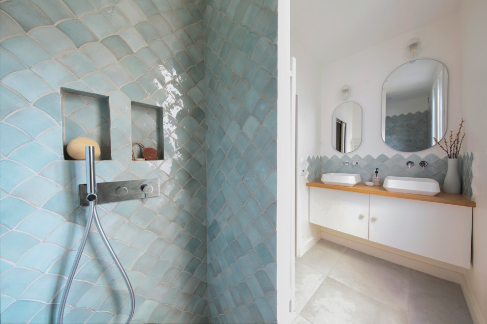 Immagine di una stanza da bagno con doccia nordica di medie dimensioni con doccia a filo pavimento, piastrelle blu, pareti bianche, lavabo a consolle, top in legno e pavimento grigio