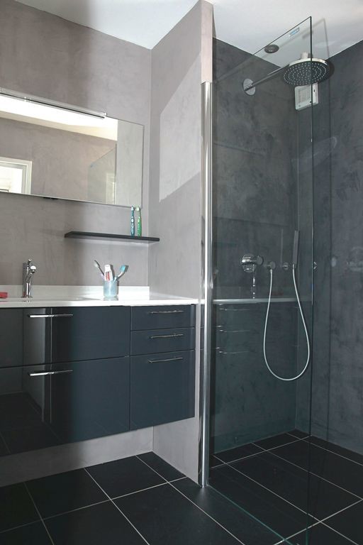 Cette image montre une petite salle d'eau design avec un placard à porte plane, des portes de placard grises, une douche à l'italienne, un carrelage gris, un mur gris, un sol en carrelage de céramique, un plan vasque, un sol noir et un plan de toilette blanc.