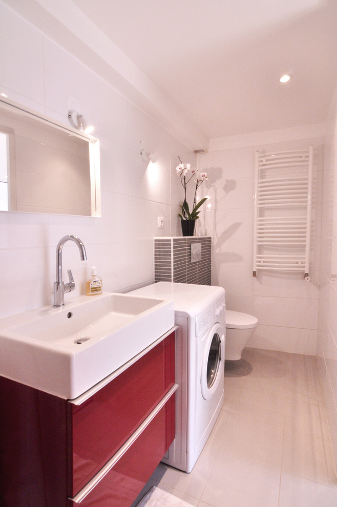Inspiration for a small modern ensuite bathroom with red cabinets, a corner shower, a wall mounted toilet, white tiles, ceramic tiles, white walls, ceramic flooring, a trough sink, tiled worktops, white floors and a shower curtain.