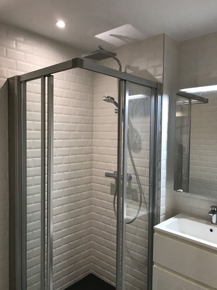 Photo of a small shower room bathroom in Paris with beaded cabinets, white cabinets, a freestanding bath, a corner shower, a wall mounted toilet, white tiles, metro tiles, white walls, cement flooring, a vessel sink, quartz worktops, multi-coloured floors, a sliding door and white worktops.