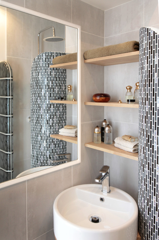 Small contemporary shower room bathroom in Paris with a built-in shower, a wall mounted toilet, grey tiles, grey walls, a built-in sink, wooden worktops, grey floors, open cabinets, beige cabinets, ceramic tiles, ceramic flooring and brown worktops.