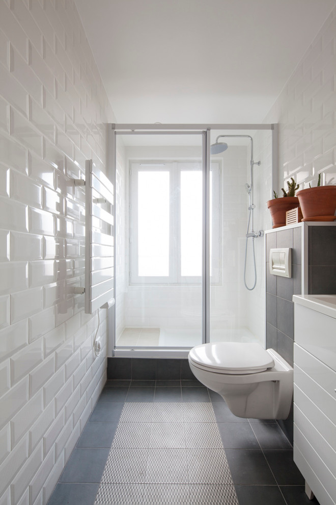 Immagine di una stretta e lunga stanza da bagno con doccia design di medie dimensioni con ante bianche, WC sospeso, pistrelle in bianco e nero, pareti bianche, doccia alcova, piastrelle diamantate e lavabo sottopiano
