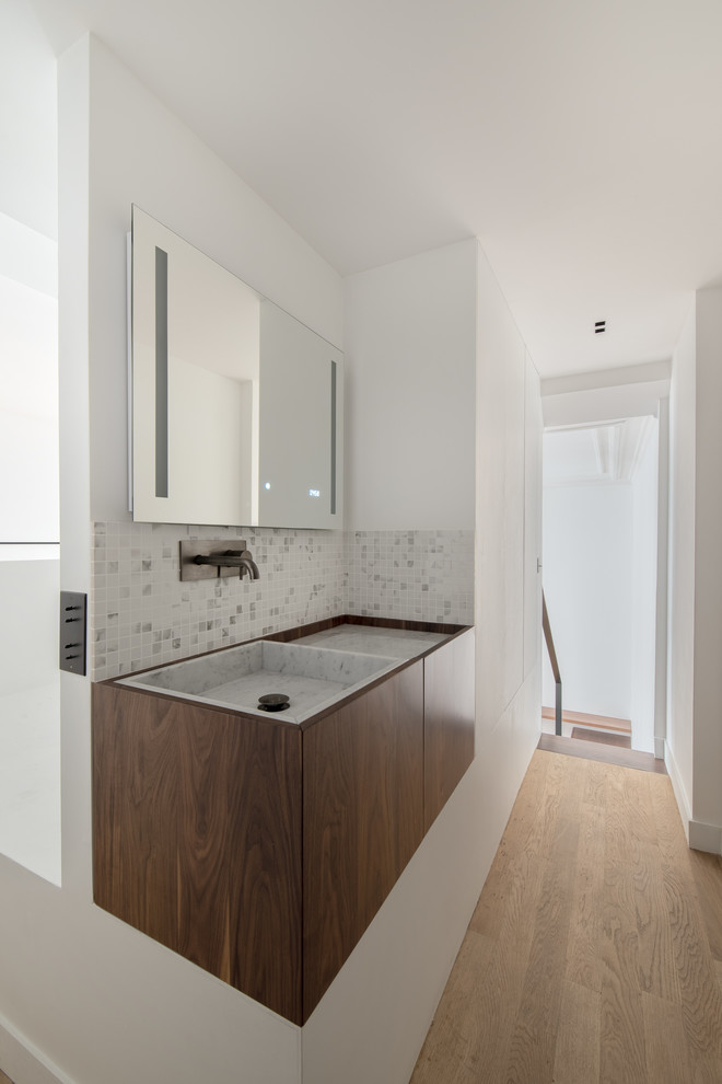 Inspiration för stora moderna vitt badrum med dusch, med luckor med profilerade fronter, bruna skåp, en kantlös dusch, vit kakel, marmorkakel, vita väggar, betonggolv, ett undermonterad handfat, marmorbänkskiva, grått golv och dusch med gångjärnsdörr