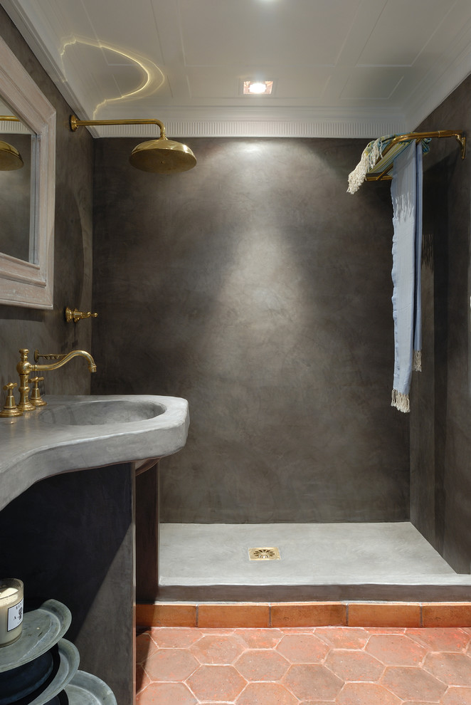 Inspiration för mellanstora 50 tals grått badrum med dusch, med en kantlös dusch, grå väggar, klinkergolv i terrakotta, öppna hyllor, grå skåp, en vägghängd toalettstol, grå kakel, ett integrerad handfat, bänkskiva i betong, orange golv och med dusch som är öppen