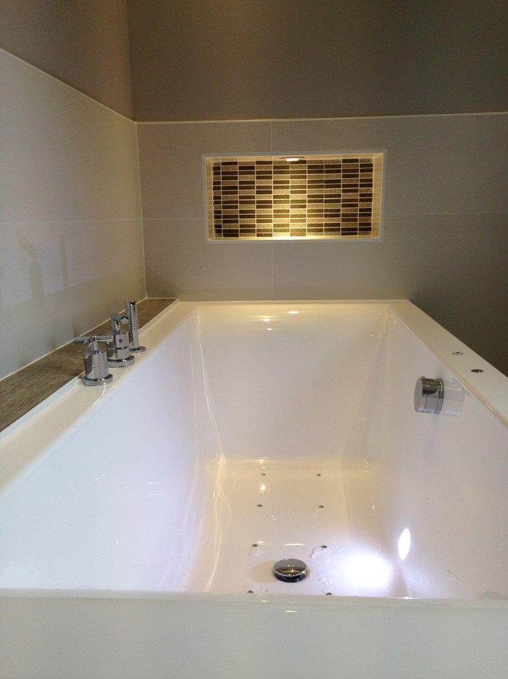 Réalisation d'une grande salle de bain principale design avec une baignoire posée, un carrelage beige, un sol en bois brun, un plan de toilette en bois et un mur blanc.
