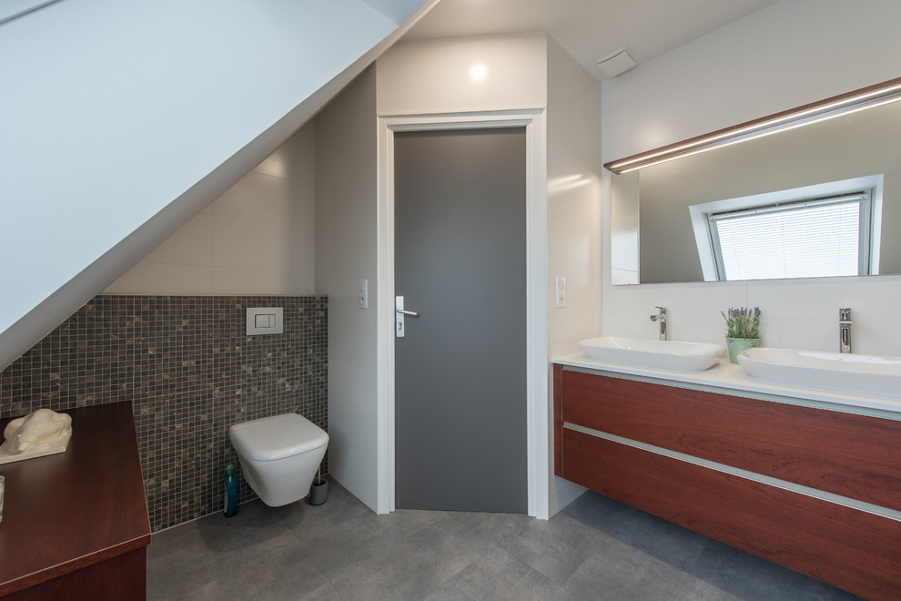 Modelo de cuarto de baño contemporáneo con jacuzzi, sanitario de pared, baldosas y/o azulejos blancos, baldosas y/o azulejos de cerámica, suelo vinílico, lavabo de seno grande, encimera de cuarcita y suelo gris