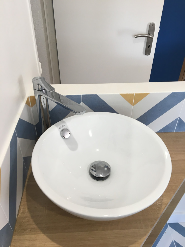 Exempel på ett litet brun brunt badrum med dusch, med öppna hyllor, bruna skåp, ett platsbyggt badkar, en vägghängd toalettstol, blå kakel, perrakottakakel, vita väggar, ett fristående handfat, träbänkskiva, blått golv och mosaikgolv