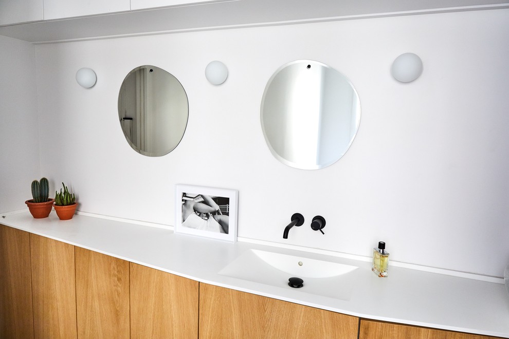 Exemple d'une salle d'eau tendance en bois clair de taille moyenne avec un placard à porte plane, une douche ouverte, un mur blanc, un sol en marbre, un plan vasque, un plan de toilette en surface solide, un sol noir et une cabine de douche à porte battante.